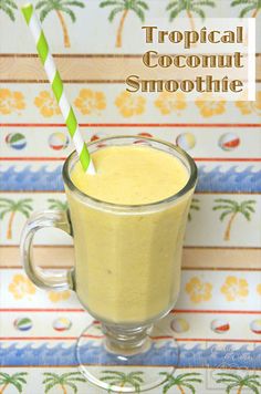 tropical coconut smoothie in a glass with a green and white striped straw