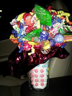 a vase filled with candy and candies in the back seat of a car at night