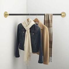 two coats hanging on a coat rack with scarfs