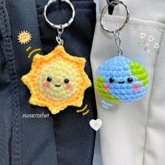 two crocheted keychains are attached to the back of pants, one has a sun and moon on it