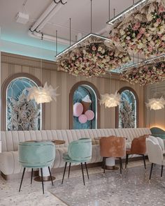 an elegant restaurant decorated in pastel colors with balloons and flowers hanging from the ceiling