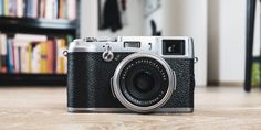 a camera sitting on the floor in front of a book shelf