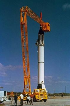 two men standing next to a large crane