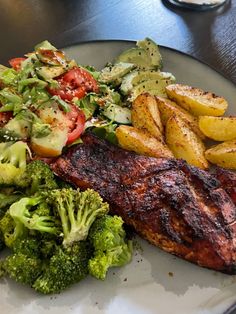 a plate with steak, potatoes and broccoli on it sitting on a table