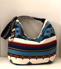 Beautiful colorful Erika Hobo Bag will put you center stage wherever you go. The geometric tribal design has colors of blue, brown, cream and black. The body of the bag measures approx. 15" H x 17" W and hangs approx 30" from top of strap to bottom of bag. Our bag is fully lined in our signature black quilted fabric, has inside pocket, magnetic closure and beaded hang ornament. Hand wash, Hang or lay flat to dry. Visit our shop https://www.etsy.com/shop/JNINGfashion? Visit our custom T-Shirt shop at www.etsy.com/shop/WordupTreasures Blue Canvas Shoulder Bag With Handles, Blue Canvas Shoulder Bag, Blue Canvas Satchel Bag With Handles, Blue Canvas Satchel With Handles, Blue Handheld Bag For Errands, Handheld Hobo Bag With Handles For Travel, Blue Rectangular Hobo Bag With Large Capacity, Blue Pouch Hobo Bag For Travel, Blue Pouch Hobo Bag For Everyday Use