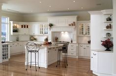 an image of a kitchen with white cabinets and wood flooring in the middle of it