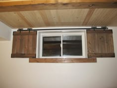 an open window with wooden shutters in a room