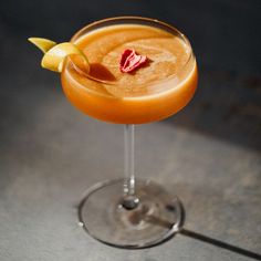 an orange cocktail with garnish on the rim