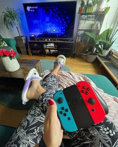 a person laying on the floor with their feet up in front of a tv playing video games