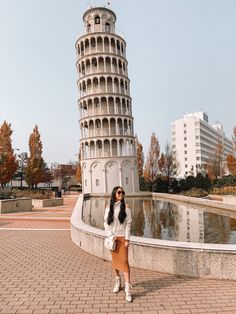 a woman standing in front of the leaning tower