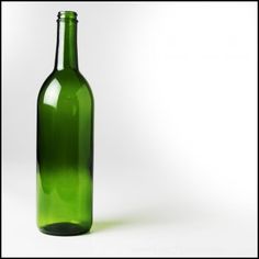 a green bottle sitting on top of a white table