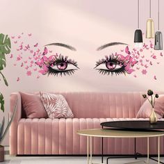 a living room with pink couches and wall decals