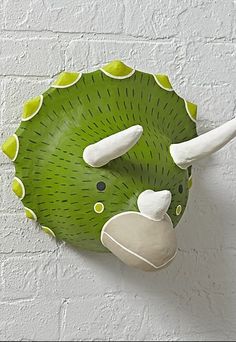 a green and white animal head on a wall mounted light switch cover in the shape of a leaf