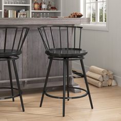 two black bar stools sitting in front of a counter