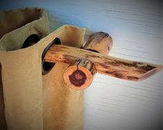 a wooden cross hanging from the side of a wall next to a bag with a tag on it