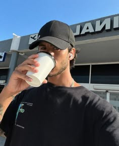 a man drinking from a white cup in front of a terminal