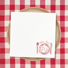 a red and white checkered table cloth with a place setting