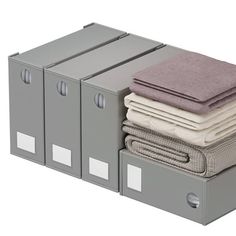 a stack of folded clothes sitting next to each other on top of metal filing cabinets