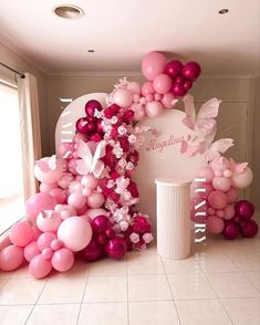 pink and white balloons are on display in a room