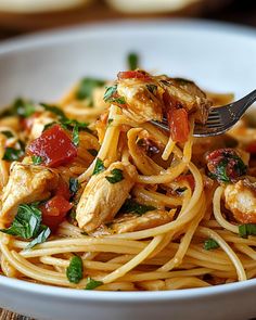 a white bowl filled with pasta and chicken