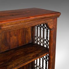 an old wooden shelf with iron bars on it's sides and shelves below the shelf