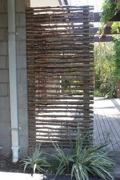 a fire hydrant sitting next to a tall wooden structure with plants growing out of it