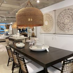 a dining room table with chairs and plates on it in front of an open floor plan