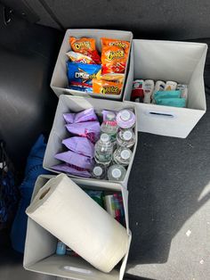 the back seat of a car with two boxes filled with snacks and other items in it