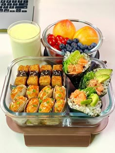 there are many different types of food in the trays on this table, including sushi and fruit