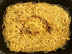 noodles are being cooked in a skillet on the stove top, ready to be eaten