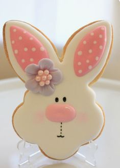 a cookie shaped like a bunny with pink ears and flowers on it's head