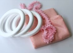 pink and white napkins with flower decorations on them sitting next to some ring holders