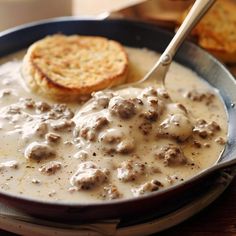 a skillet filled with meatballs and gravy next to some crackers