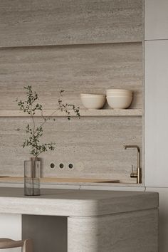 a kitchen counter with two bowls on it and a vase filled with flowers in the middle