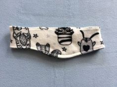 a white headband with black and white designs on it, hanging from a wall