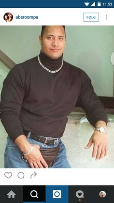 a man wearing a black shirt and jeans posing for the camera with his hand on his hip