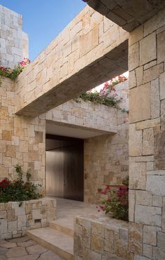 an entrance to a building with flowers growing out of it