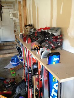 skis and snowboards are lined up on a shelf