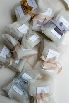 several small packages with ribbons tied to them on a white tablecloth covered plate and napkins