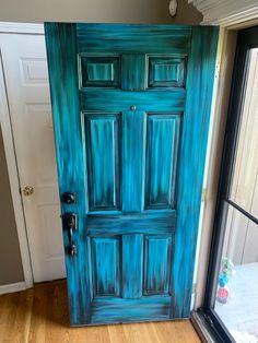 a blue painted door in front of a window