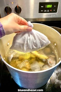 a person holding a cloth over a pot filled with boiling water