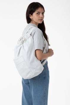 This garment-dyed, bull denim bag has a round-shaped bottom with plenty of height to fill with taller items. It is designed like a backpack with two straps that double also function as a drawstring to keep your belongings safe. We've also added a front pocket for easy access. Our bags are made in our in house factory in Los Angeles, California by workers earning a living wage. Each bag is manufactured and then dyed in batches, giving the thick textile of the bag a weathered texture. These bags c Versatile Everyday Drawstring Bag With Adjustable Strap, Everyday Drawstring Shoulder Bag With Adjustable Strap, Everyday Drawstring Backpack With Adjustable Strap, Casual Cotton Backpack Styled As Shoulder Bag, Everyday Use Drawstring Backpack With Adjustable Strap, Large Capacity Cotton Backpack, Versatile Everyday Gym Bag With Pockets, Large Capacity Cotton Standard Backpack, Casual Drawstring Shoulder Bag For Everyday Use