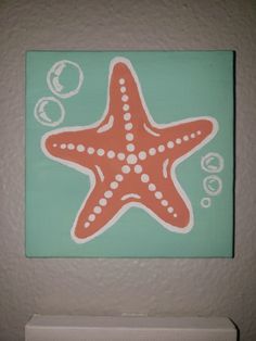 an orange and white starfish sitting on top of a green wall next to bubbles