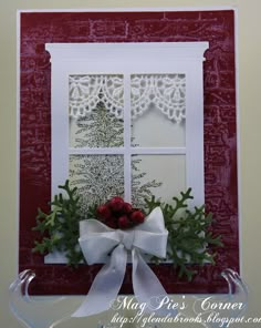 a close up of a card with a bow and flowers in front of a window