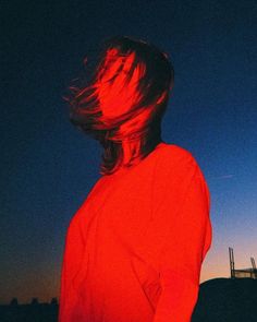 a woman with her hair blowing in the wind at sunset or dawn, looking back