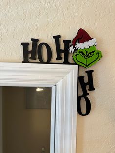 the grin face has been painted on the wall next to the mirror, which reads ho ho ho