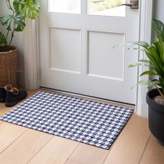 a pair of black and white shoes sitting on the floor in front of a door