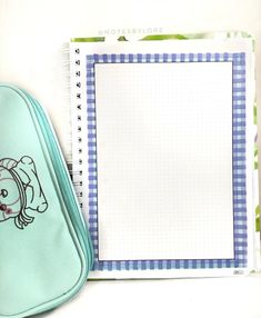 an open notebook with a cartoon dog on it next to a pen and pencil case