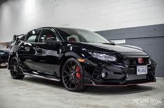 a black car parked in a garage next to other cars