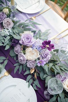 the table is set with purple and white flowers